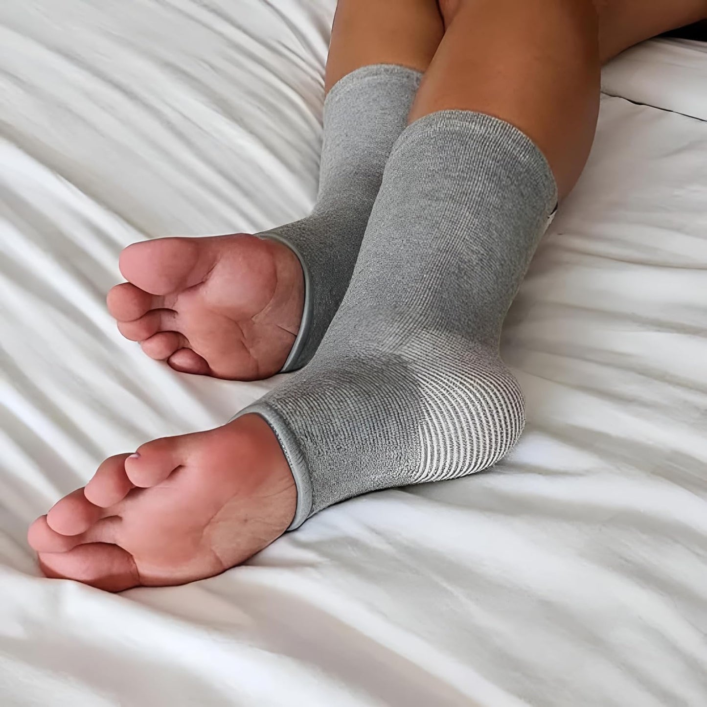 Person wearing grey compression ankle sleeves on bed, IndianChic health care product